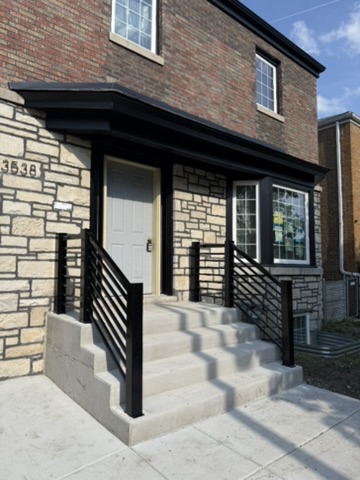 Custom black steel entry railings installed by Prime Welding in Chicago